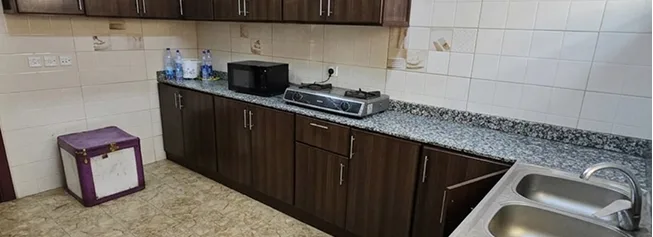 Shared kitchen with cabinets, stove and sink for couriers