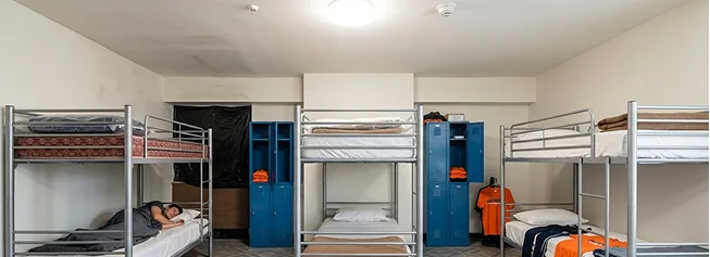 Furnished shared dormitory rooms with bunk beds and lockable storage